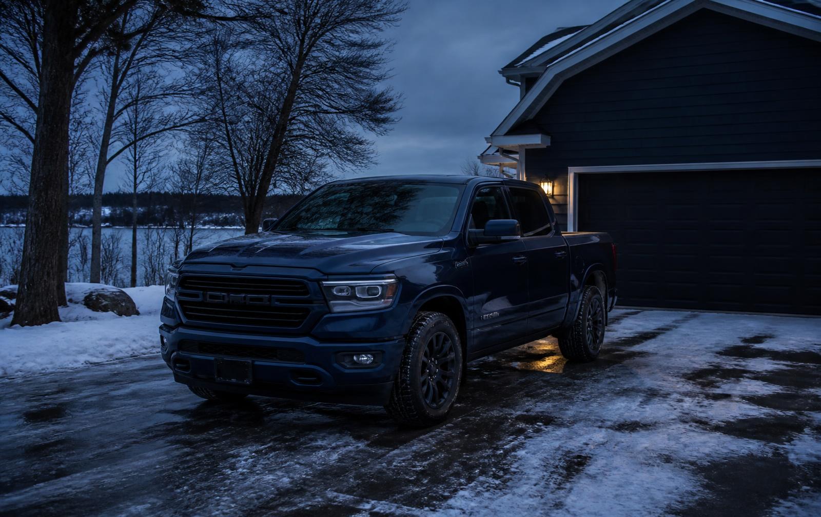 Dark pickup truck parked in a snowy West Michigan driveway on a winter evening